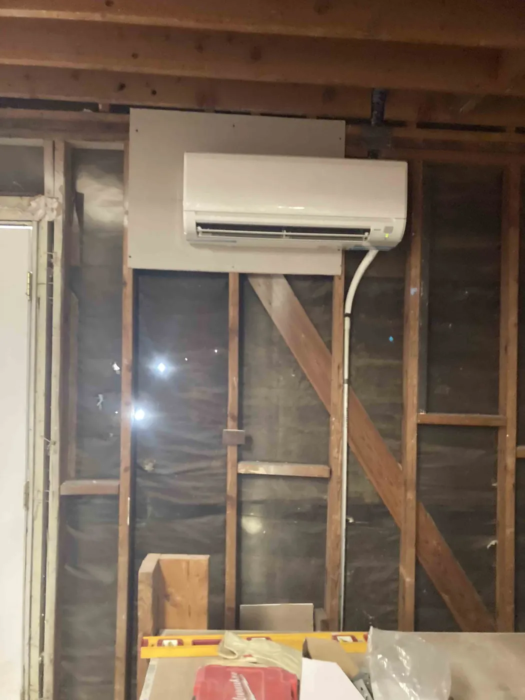 Mini split indoor head mounted on an open framed wall before finishing
