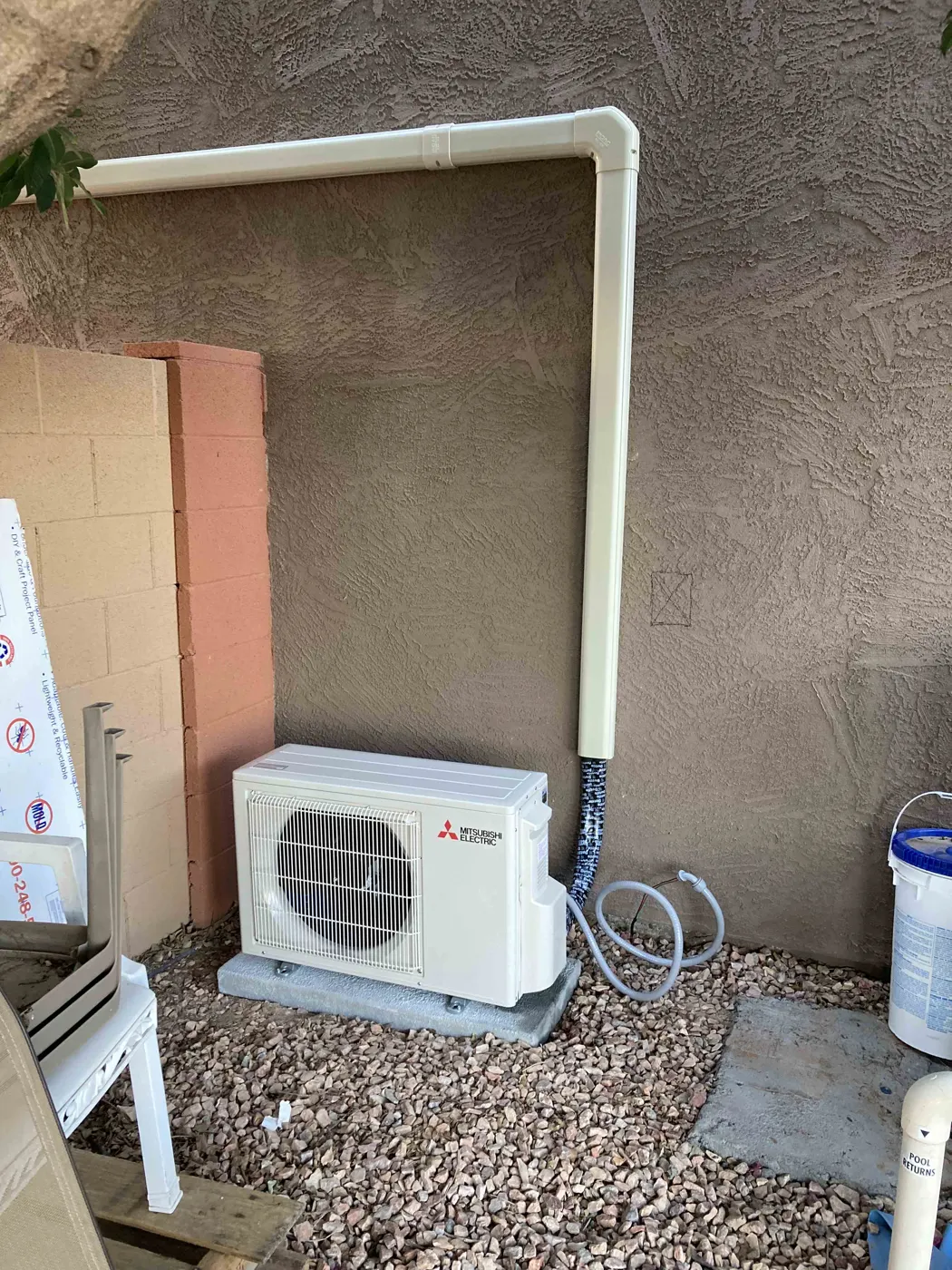 Mini split outdoor condenser on a pad with covered line set