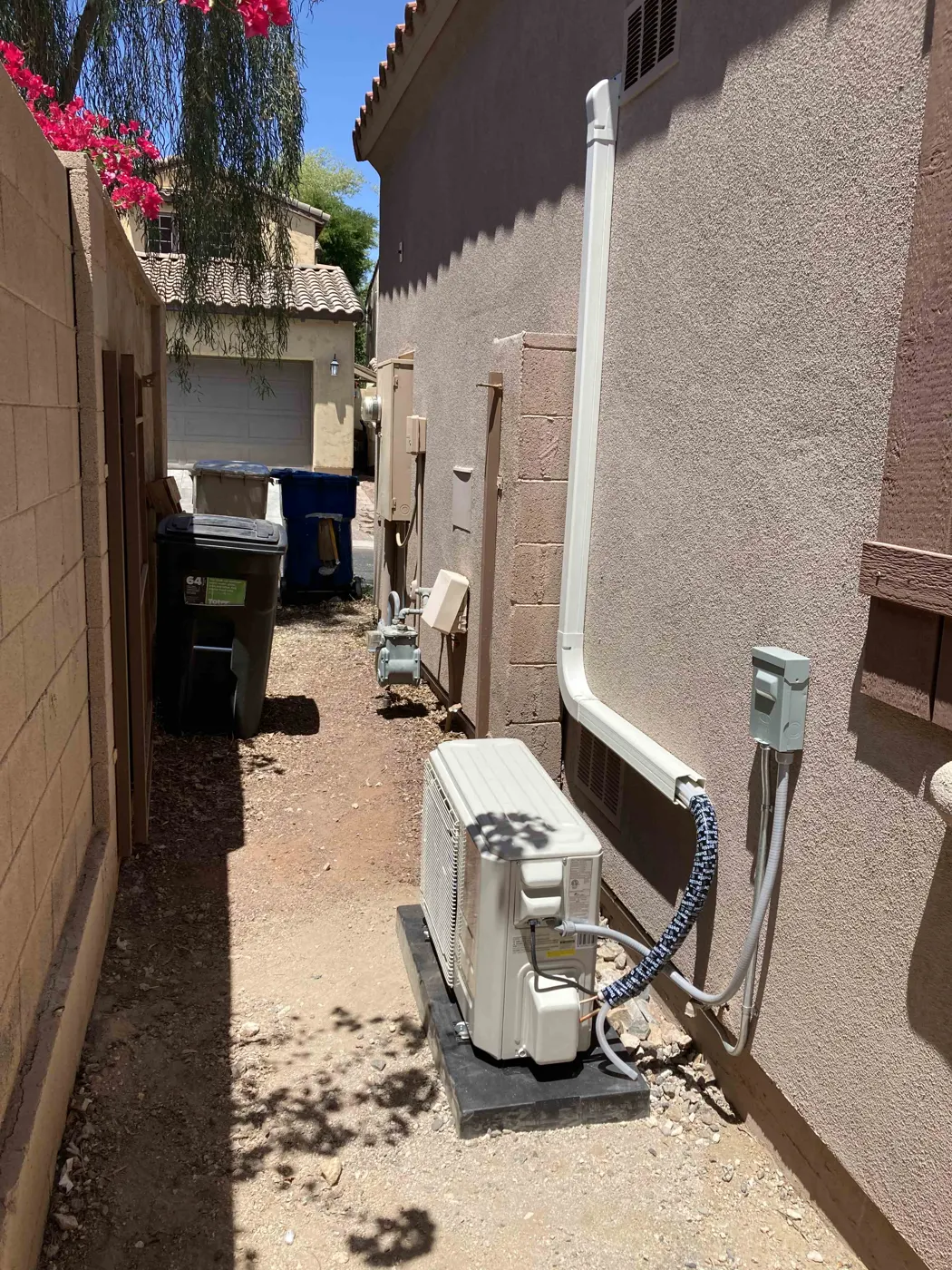 Mini split outdoor unit in a side yard with line set cover